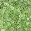 A close-up view of a mix of transparent iridescent green acrylic pearls of various sizes.