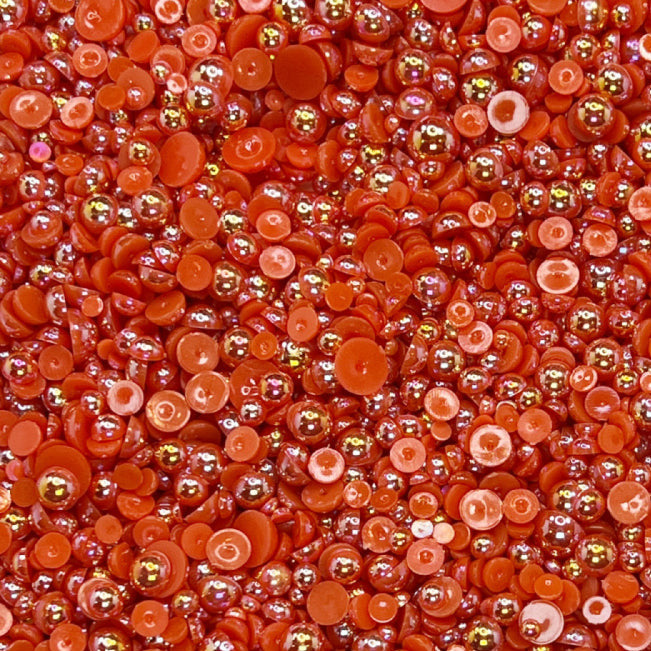 A close-up view of cherry red flat-back acrylic pearls of various sizes, intended for crafting and embellishment purposes.