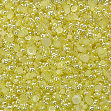 A close-up view of yellow flat-back acrylic pearls intended for crafting and embellishment purposes, with the text 'LEMON MERINGUE ACRYLIC FLAT-BACK BAUBLES EMBELLISHMENT MIX' displayed.