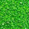 A close-up view of small, round, green glow-stick acrylic flat-back baubles embellishments.