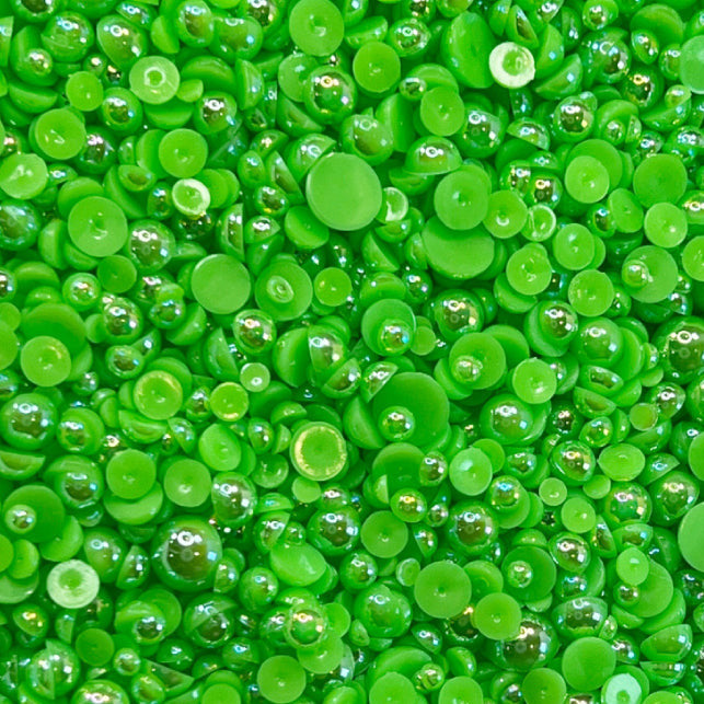 A close-up view of small, round, green glow-stick acrylic flat-back baubles embellishments.