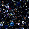 A close-up view of a mix of iridescent black flat-back beads in various sizes, intended for crafting purposes.