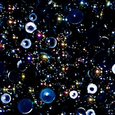 A close-up view of a mix of iridescent black flat-back beads in various sizes, intended for crafting purposes.