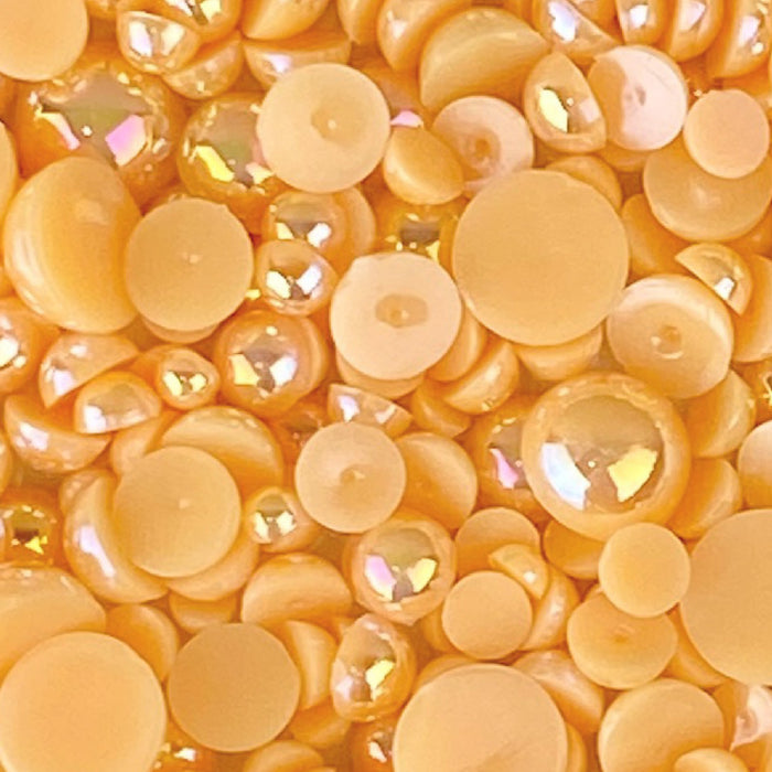 A close-up image of flat-back acrylic pearls in varying shades of orange and yellow, with a label stating 'CANTALOUPE ACRYLIC FLAT-BACK BAUBLES EMBELLISHMENT MIX'.