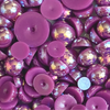 A close-up view of purple acrylic flat-back baubles embellishments, with a label indicating the brand and product name.