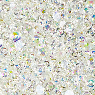 A close-up image of iridescent clear flat-back beads in various sizes, intended as embellishments.