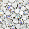 A variety of gray resin flat-back beads in an assortment of sizes, displayed on a surface.